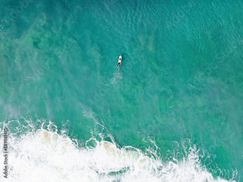 Obraz na płótnie View from above, stunning aerial view of a person surfing on a turquoise ocean. Fuerteventura, Canary Islands, Spain. w salonie