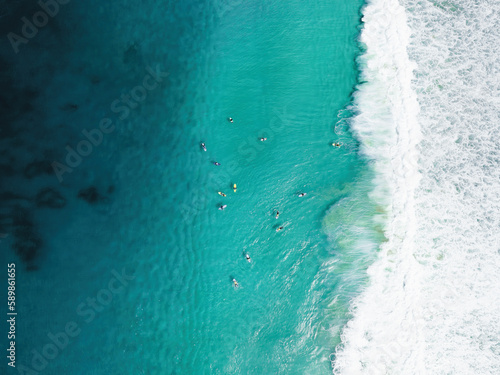 View from above, stunning aerial view of a person surfing on a turquoise ocean. Fuerteventura, Canary Islands, Spain. © Travel Wild