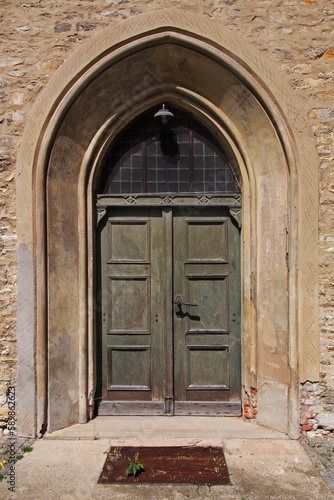 Pointed gothic arch with ancient wooden door at St. Moritz church in the old town of Halberstadt in Sachsen-Anhalt region, Germany