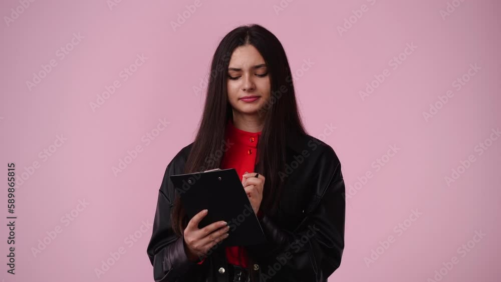 4k video of one girl which thinks and notes something with a pen on tablet over pink background. 4k video of one girl which thinks and notes something with a pen on tablet over pink background.