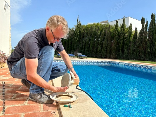 Man fixing the swimming pool light of a residential swimming pool