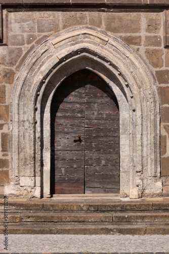 Pointed gothic arch with ancient wooden door at St. Katharinen monastery church in the old town of Halberstadt in Sachsen-Anhalt region  Germany