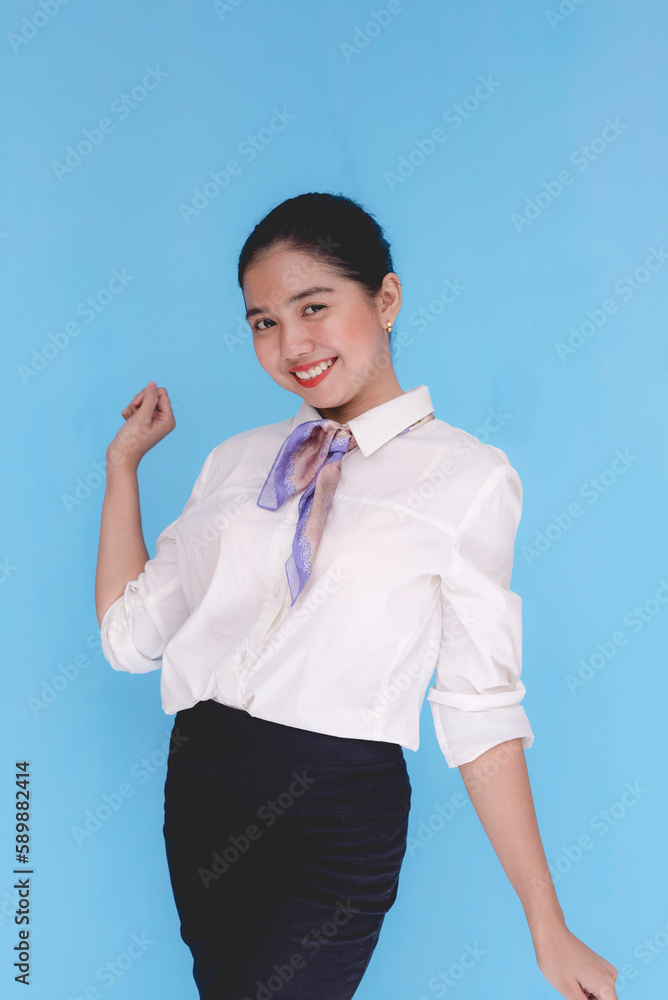 A flight attendant or a stewardess dancing. A hostess posing happily. Isolated on a blue background. A flight attendant or a stewardess dancing. A hostess posing happily. Isolated on a blue background.