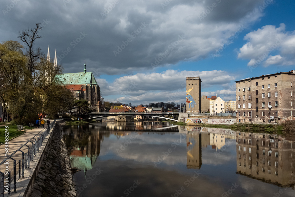 View along Neisse river in Görlitz. Old Town Bridge connects Görlitz with Zgorzelec. St. Peter and Paul church in the background.