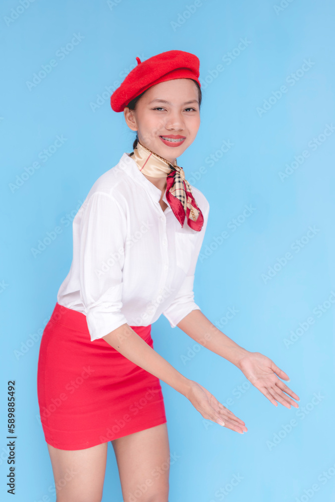 A flight attendant or stewardess guiding people to the left side downwards of the airplane. A hostess presenting the storage under the seats. Isolated on a blue background. A flight attendant or stewardess guiding people to the left side downwards of the airplane. A hostess presenting the storage under the seats. Isolated on a blue background.