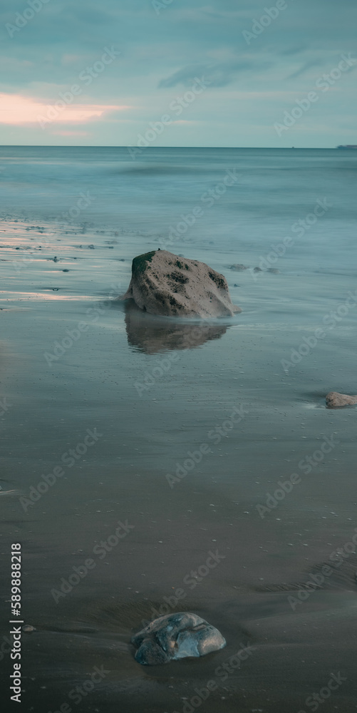 Naklejka premium Long exposure seascape of rocks on a beach