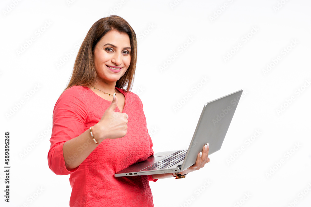 Young woman holding laptop in hand and showing thumps up.