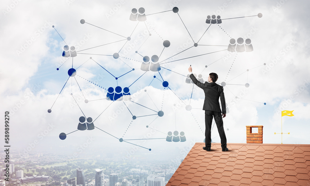 Businessman on house roof presenting networking and connection concept. Mixed media Businessman on house roof presenting networking and connection concept. Mixed media