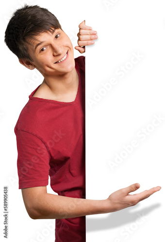 Fotografie Young man looking around a corner and showing off a blank sign