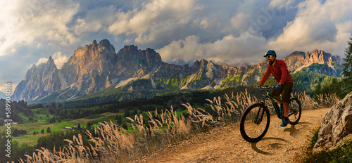 A man ride electric mountain bikes in the Dolomites in Italy. Mountain biking adventure on beautiful mountain trails.