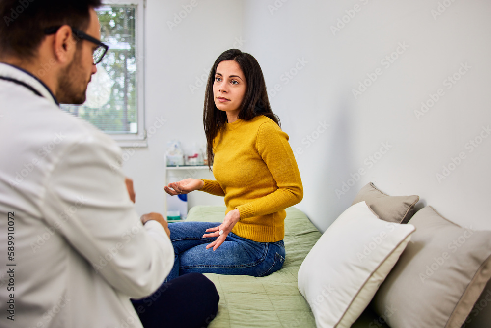 A worried female patient talking with her male doctor about her health at the clinic. A worried female patient talking with her male doctor about her health at the clinic.