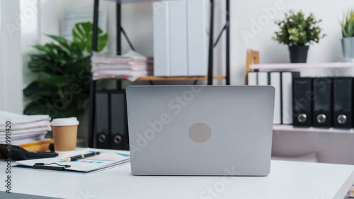 Stylish workspace with laptop, notebook, blank screen laptop on white table of bookkeeping.