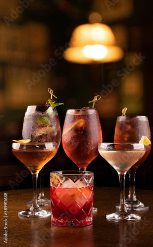 collection of refreshing cocktail glass in lillet spritz aperol party with lime red berries and negroni mint and ice with blur pub background in chilled glass