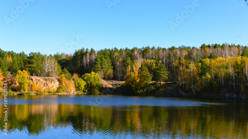 Lake in the autumn forest in the rays of the evening sun