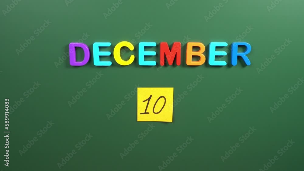 Hand sticking a sticker 10 December calendar day on school board. 10 ...