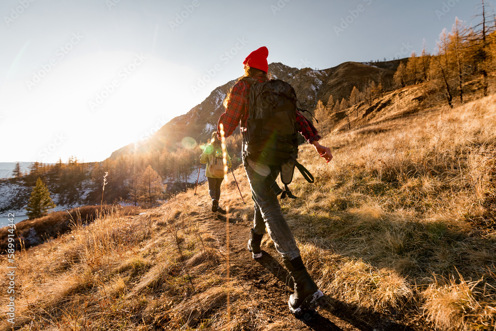 Two hikers walks with backpacks in mountains. Hiking concept Two hikers walks with backpacks in mountains. Hiking concept