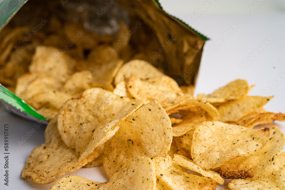 Potato chips, delicious spicy for crips, thin slice deep fried snack fast food in open bag.