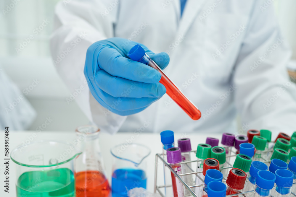 Fototapeta premium Scientist holding erlenmeyer flask, conical flask glassware with red color liquid solution in science chemistry laboratory.