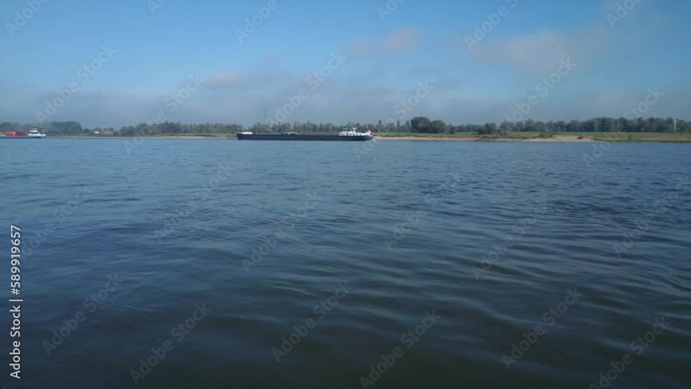 Netherlands, Millingen aan de Rijn, 09-27-2022. Aerial view freight transport by Rhine river. Panning 4K Netherlands, Millingen aan de Rijn, 09-27-2022. Aerial view freight transport by Rhine river. Panning 4K
