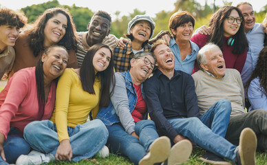 Group of multi generational people having fun together outdoor - Multiracial friends enjoy day at city park
