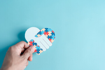 Hand puzzle symbol paper cut out of awareness for autism spectrum disorder family support. Autism World Awareness Day
