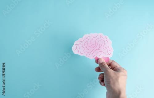 Hand holding human brain paper cut, idea creative intelligence thinking or Awareness of Alzheimer, Parkinson's disease, dementia, stroke, seizure or mental health. Neurology and Psychology care.