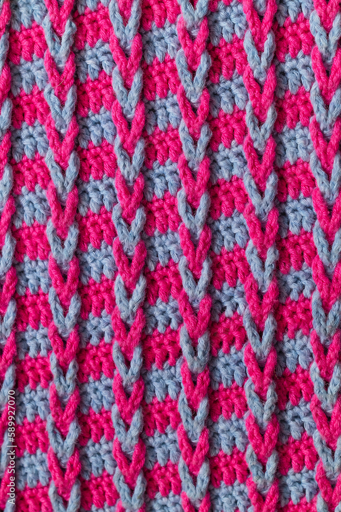 Knitted fabric background. Pink blue crochet chain loop braids pattern.