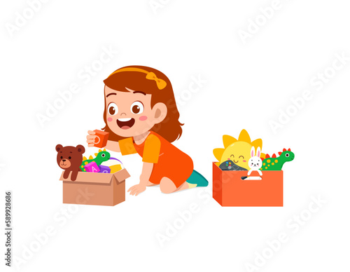 little kid put toys to box for donation