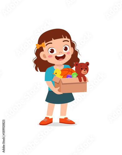 little kid standing and holding a box full of toys for donation