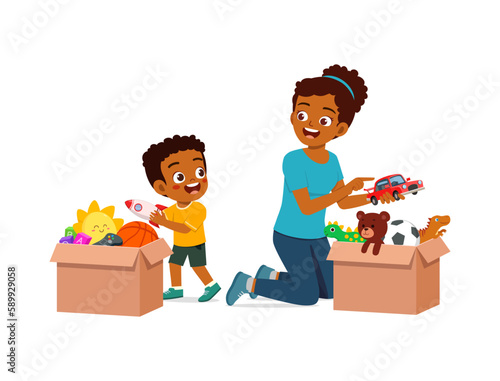 little kid put toys to box for donation with mother