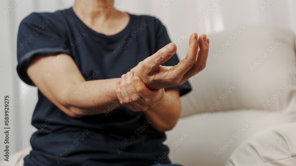 Close up hands of asian senior elderly woman with parkinson's disease symptom, hand numbness, finger lock, hand pain. Mental health and elderly care concept Close up hands of asian senior elderly woman with parkinson's disease symptom, hand numbness, finger lock, hand pain. Mental health and elderly care concept