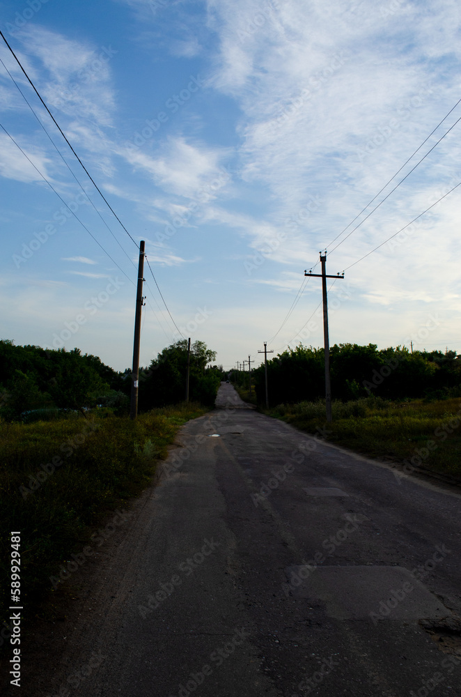 Road in Ukraine in the village in the evening against the sky