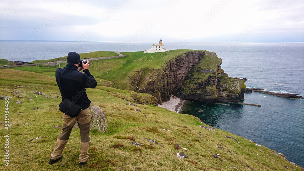 Ein Mann fotografiert den Leuchtturm von Stoer an der Ostküste Schottland. Seit 1870 hilft es den Seefahrern vor der Küste Assynt im Minch.