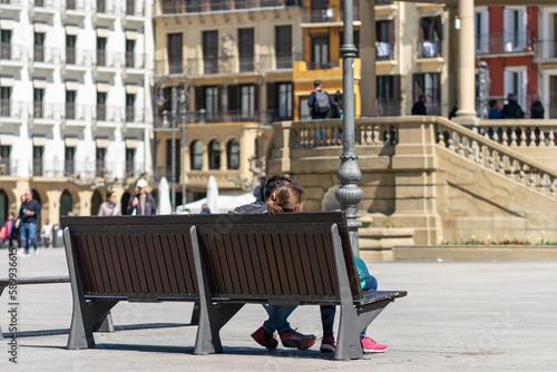 Tourist couple on a bench in the sun. Castle Square, Pamplona