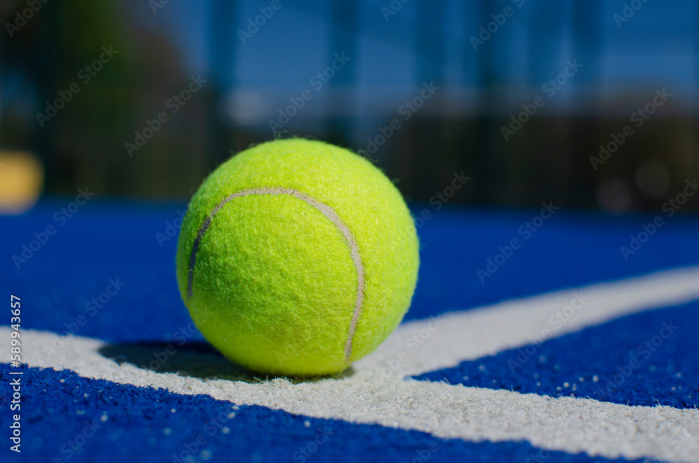 close-up shot of a ball on a blue paddle tennis court