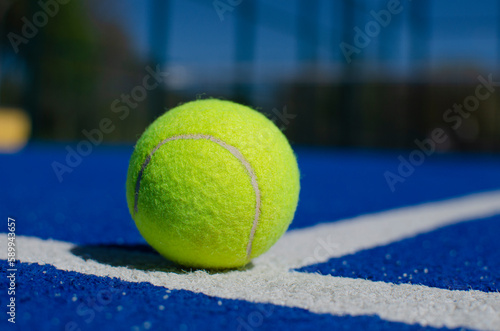 close-up shot of a ball on a blue paddle tennis court © Vic