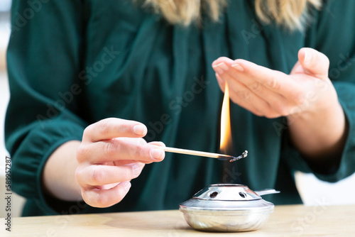 Young woman burning herself by lighting a fondue stove.
