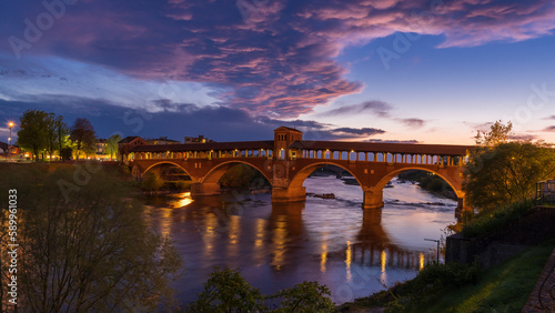 Ponte Coperto (covered bridge) over Ticino river in Pavia at blue hour, Lombardy, italy.