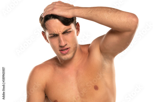 Closeup portrait of shirtless 20s man with headache isolated over white background