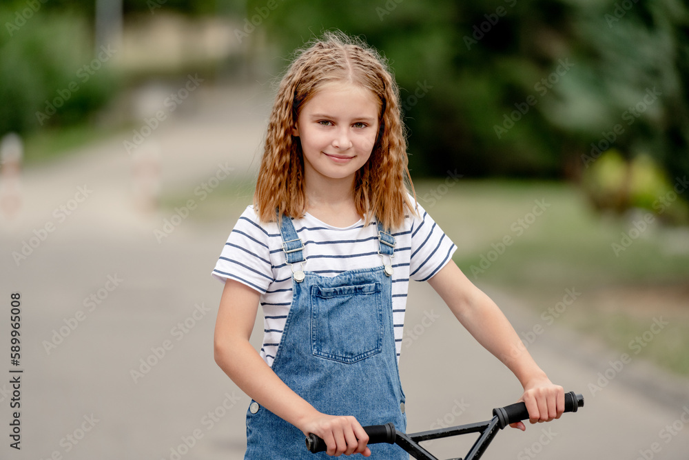 Little girl riding a kick scooter on a street near home Little girl riding a kick scooter on a street near home