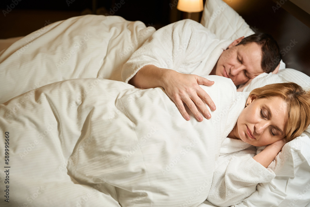 Sweet middle-aged lady is taking sweet nap on soft pillow