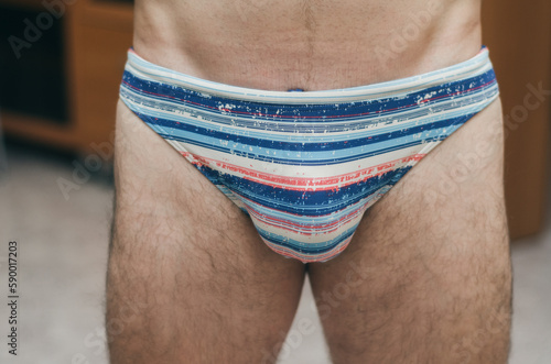 man with hairy legs in swimming trunks