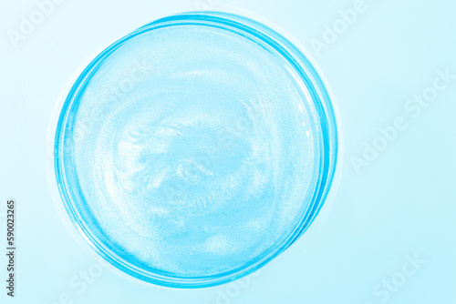 Blue liquid with luster. In a Petri dish. Laboratory research of cosmetics, gel, medicine. Chemistry