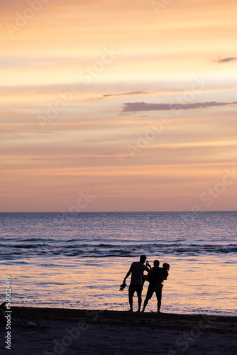 silhouette of a family on the beach enjoying sunset