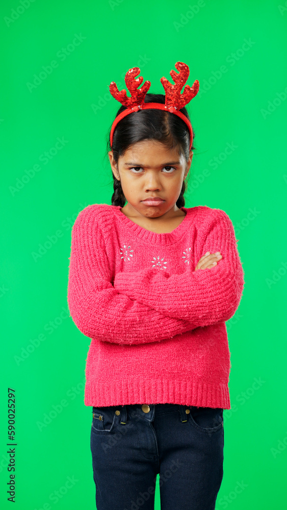 Portrait, christmas and an unhappy girl on a green screen background standing arms crossed in anger. Kids, sad and frustrated with a miserable little female child looking moody, annoyed or upset Portrait, christmas and an unhappy girl on a green screen background standing arms crossed in anger. Kids, sad and frustrated with a miserable little female child looking moody, annoyed or upset