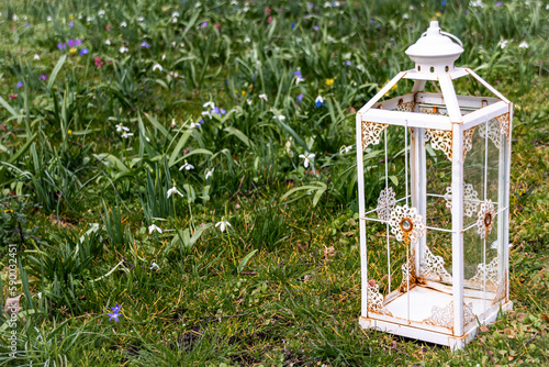 Rusty lantern in a meadow with flowers