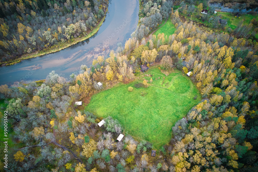 This photo features a heart-shaped lawn in the middle of an autumn forest, located near river. The image was captured on a cloudy day, adding a moody and atmospheric feel to the scene. This photo features a heart-shaped lawn in the middle of an autumn forest, located near river. The image was captured on a cloudy day, adding a moody and atmospheric feel to the scene.