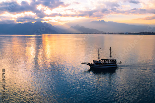 Landscape of boat - yacht in the Mediterranean sea with mountains in the distance during the sunset, Antalya, Turkey © Codrin Rusu