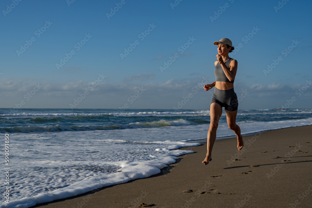 beautiful young girl is engaged in jogging on the seashore front view