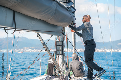 Voyage race sail on professional sport sea yacht. Yachting summer vacation cruise . Captain yachtsman sailing. Sails on mast. Ocean ship boa travel. Enjoy trip on sailboat front deck. Training school